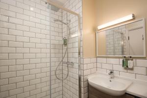 a white bathroom with a sink and a shower at The Tynemouth Castle Inn - The Inn Collection Group in Tynemouth