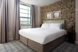 a bedroom with a large bed and a window at The Tynemouth Castle Inn - The Inn Collection Group in Tynemouth