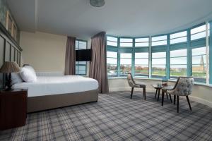 a hotel room with a bed and a table and chairs at The Tynemouth Castle Inn - The Inn Collection Group in Tynemouth