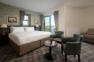 a hotel room with a bed and a couch at The Tynemouth Castle Inn - The Inn Collection Group in Tynemouth