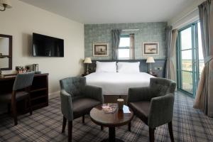 a hotel room with a bed and two chairs and a table at The Tynemouth Castle Inn - The Inn Collection Group in Tynemouth