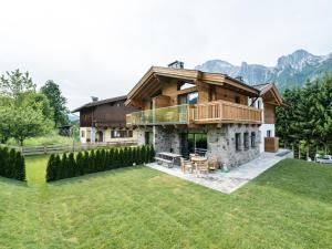 a large house with a deck on top of a yard at Chalet Schneelöwe XL in Leogang