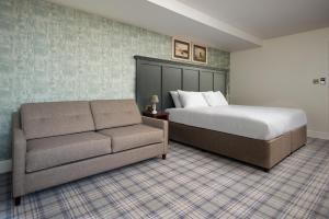 a bedroom with a bed and a couch at The Tynemouth Castle Inn - The Inn Collection Group in Tynemouth