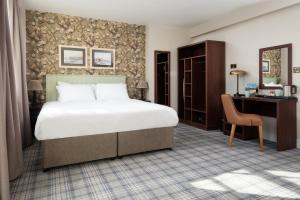 a bedroom with a large bed and a desk at The Tynemouth Castle Inn - The Inn Collection Group in Tynemouth