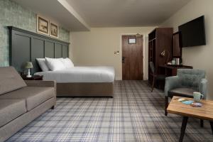 a hotel room with a bed and a couch and a table at The Tynemouth Castle Inn - The Inn Collection Group in Tynemouth