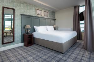 a hotel room with a bed and a mirror at The Tynemouth Castle Inn - The Inn Collection Group in Tynemouth
