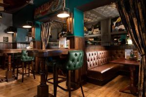 a bar with a wooden table and leather seats at The Tynemouth Castle Inn - The Inn Collection Group in Tynemouth