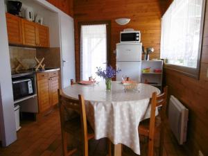 eine Küche mit einem Tisch und einer Blumenvase darauf in der Unterkunft Les bruyeres in Brocas