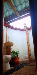 a bathroom with a toilet and a plant at Hotel Engatama in Moniquirá
