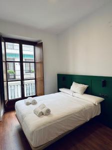 1 dormitorio con 1 cama grande y toallas. en CATEDRAL SQUARE, en Sevilla