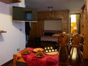 uma sala de estar com mesa e cadeiras e uma cozinha em PERLA DI MONTAGNA em Courmayeur