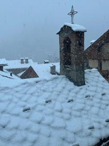 a church with a cross on top of a pile of snow at PERLA DI MONTAGNA in Courmayeur