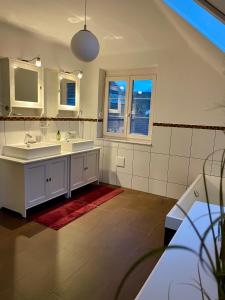 ein Badezimmer mit einem weißen Waschbecken und einem Spiegel in der Unterkunft Casa Anna in Villach