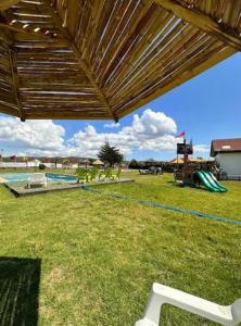 Patio Roma في كويلوتا: اطلالة على ملعب مع مسبح ومظلة خشبية