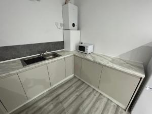 a small kitchen with a sink and a microwave at Manchester in Style: 1-Bed Oasis in Manchester