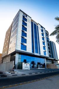 a tall building with blue windows on a street at DAM hodoo دام الهــــــــدوء in Al Khobar