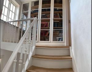 a staircase with a book shelf with books at Nordsoe Housing-Rørby Kalundborg in Kalundborg
