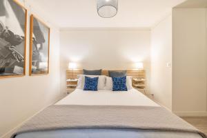 a bedroom with a large bed with blue pillows at Duran Duran in Paris