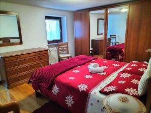 Un dormitorio con una cama con un edredón rojo. en Appartamento di montagna LO GROP, en Chambave