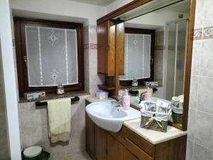 un baño con lavabo y espejo en Appartamento di montagna LO GROP, en Chambave 25 fotos más