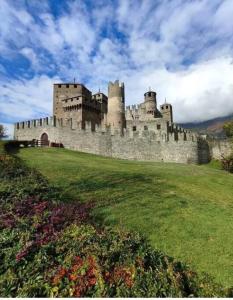 un castillo en lo alto de un exuberante campo verde en Appartamento di montagna LO GROP, en Chambave