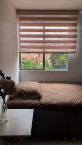 1 dormitorio con ventana, cama y mesa en Habitación en apartamento compartido en Envigado en Envigado