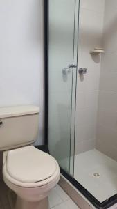 a bathroom with a toilet and a glass shower at Habitación en apartamento compartido en Envigado in Envigado