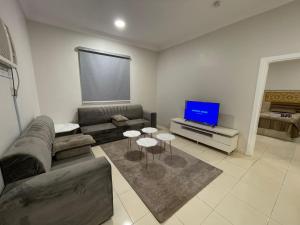 a living room with a couch and a tv at شقه راقيه سويت قريبه من المسجد النبوي تتسع لاربع اشخاص in Al Madinah