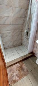 y baño con ducha y alfombra. en Casita happy feet and tours drake bay, en Drake