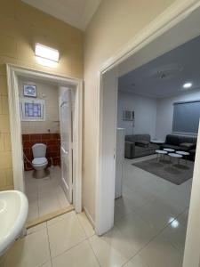 a bathroom with a toilet a sink and a living room at شقه راقيه سويت قريبه من المسجد النبوي تتسع لاربع اشخاص in Al Madinah