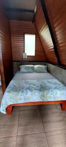 1 dormitorio con 1 cama en una habitación de madera en Casita happy feet and tours drake bay en Drake