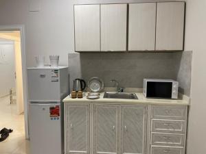 a kitchen with a sink and a refrigerator at شقه راقيه سويت قريبه من المسجد النبوي تتسع لاربع اشخاص in Al Madinah