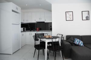 Una sala de estar con mesa y sillas y una cocina. en Art life apartments (cotton), en Alanya