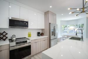 a kitchen with white cabinets and a stainless steel refrigerator at Havana House Miami in Miami