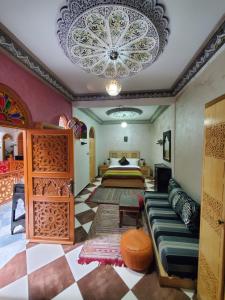 1 dormitorio con cama y lámpara de araña en Riad Royal, en Meknès