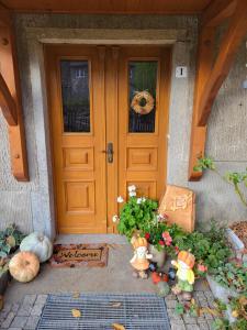 a front door of a house with pumpkins and flowers at Ferienwohnung Am Wasserturm mit kleinem Bauernhof in Baruth