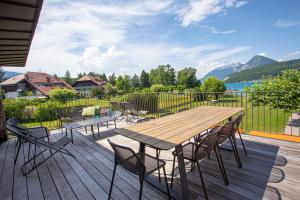 une terrasse en bois avec une table et des chaises en bois dans l'établissement Le Clos Marcel, à Duingt