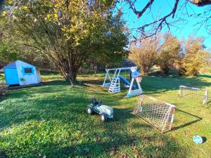 um quintal com um parque infantil e um baloiço em Honey hill apartment Fruska Gora em Čerević