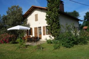 a white house with a table and an umbrella at Bourdiscat in Campagne