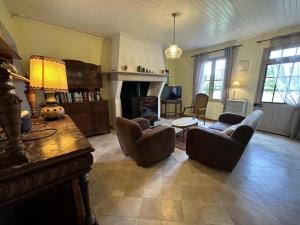 a living room with a couch and chairs and a fireplace at Bourdiscat in Campagne