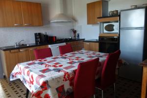a kitchen with a table with red chairs and a refrigerator at Bourdiscat in Campagne +9 photos