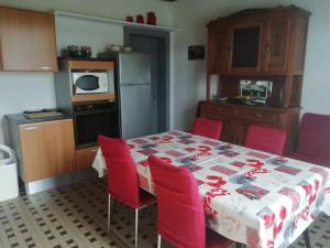 a kitchen with a table with red chairs and a kitchen with a tableablish at Bourdiscat in Campagne