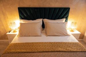 un grand lit avec deux lampes sur deux tables dans l'établissement Kasa Nouveau, à Oradea