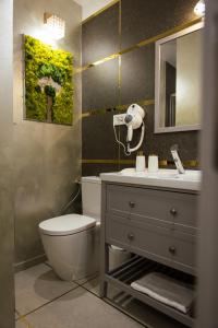 a bathroom with a toilet and a sink and a mirror at Kasa Nouveau in Oradea