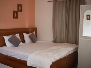 a bedroom with a bed with white sheets and pillows at Flow House in Rishīkesh