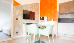 een keuken met witte stoelen en een tafel met een televisie bij Casa Scotto in Pisa