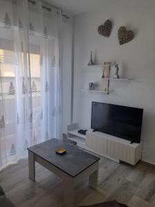 ein Wohnzimmer mit einem Flachbild-TV und einem Couchtisch in der Unterkunft Paisaje Príncipe in Alcantarilla