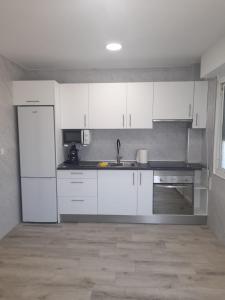 a kitchen with white cabinets and a sink at Paisaje Príncipe in Alcantarilla