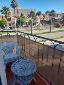 einen Balkon mit 2 Stühlen, einem Tisch und einer Straße in der Unterkunft Paisaje Príncipe in Alcantarilla