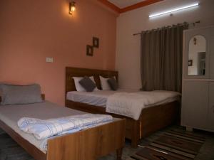 a bedroom with two beds and a mirror at Flow House in Rishīkesh